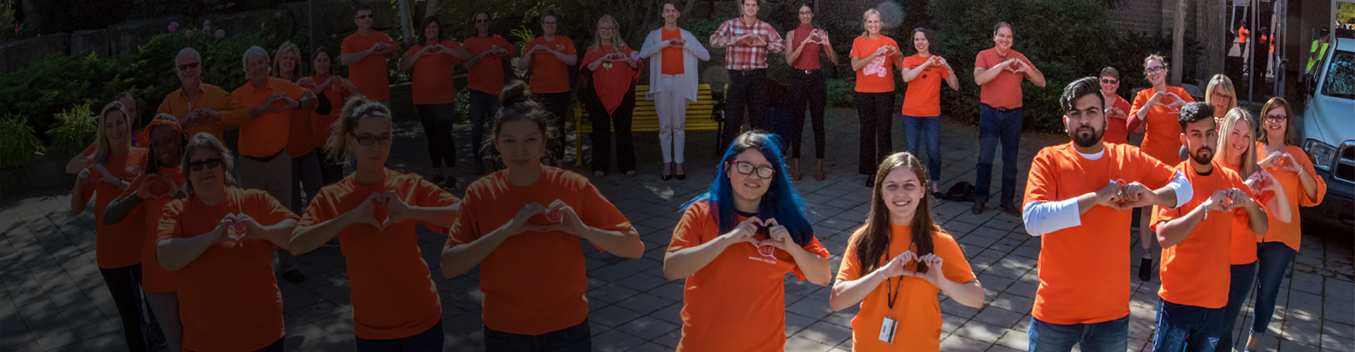 Indigenous students and allies in orange shirts standing in a circle