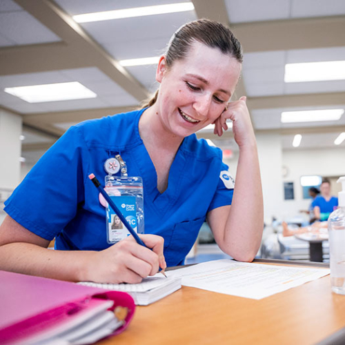 Student in Nursing Lab writing information down on paper